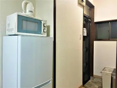 a microwave sitting on top of a refrigerator at House Kadoi202 in Tokyo
