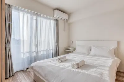 a bedroom with a white bed with two towels on it at Ostay Nippori Hotel Apartment (Nishi-Nippori Sta.) in Tokyo