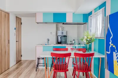 a kitchen with red chairs and a table at Ostay Nippori Hotel Apartment (Nishi-Nippori Sta.) in Tokyo