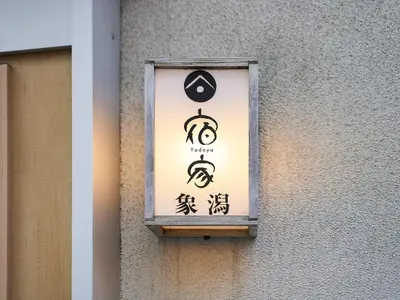a sign on the side of a building with chinese writing at YADOYA Kisakata in Tokyo