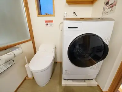 a washing machine sitting next to a toilet in a bathroom at YADOYA Kisakata in Tokyo