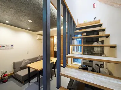a room with a staircase and a couch and a table at YADOYA Kisakata in Tokyo