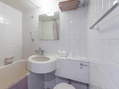 a white bathroom with a sink and a toilet at Hotel Koryukaku in Tokyo