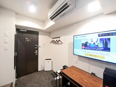 a meeting room with a projector screen and a door at HOTEL LiVEMAX Asakusa-Ekimae in Tokyo