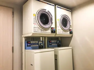 two washing machines and a washer and dryer in a room at HOTEL LiVEMAX Asakusa-Ekimae in Tokyo