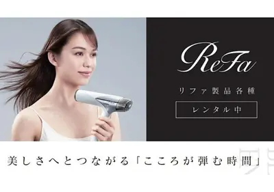a woman brushing her hair with a hair dryer at HOTEL LiVEMAX Asakusa-Ekimae in Tokyo