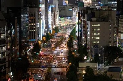 a busy city street at night with traffic at MIMARU Tokyo Shinjuku West in Tokyo