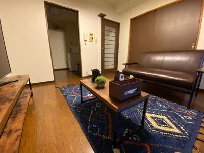 a living room with a leather couch and a coffee table at Residential Hotel Bevel Tokyo in Tokyo