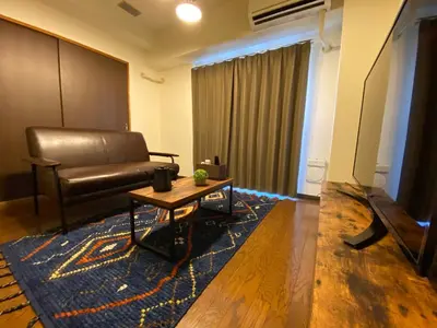 a living room with a leather couch and a table at Residential Hotel Bevel Tokyo in Tokyo