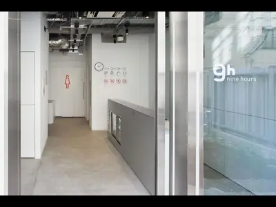 a hallway in a building with a wall of windows at 9h nine hours Hamamatsucho in Tokyo