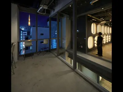 a man standing in a room with a view of a city at 9h nine hours Hamamatsucho in Tokyo