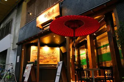 two red umbrellas in front of a store at \u90fd\u96fb\u5c4b TodenHotel in Tokyo