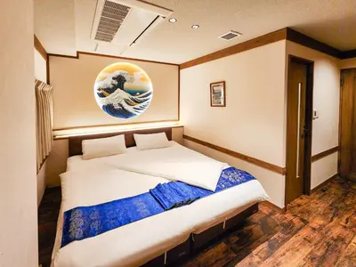 a bedroom with a bed with a painting of a wave at \u90fd\u96fb\u5c4b TodenHotel in Tokyo
