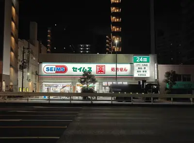 a store with signs on the side of a street at night at \u90fd\u96fb\u5c4b TodenHotel in Tokyo