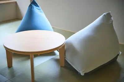 a table and a pillow next to a stool at \u30b3\u30f3\u30c9\u30df\u30cb\u30a2\u30e0\u30db\u30c6\u30eb \u6e0b\u8c37GOTEN Condominium Hotel Shibuya GOTEN in Tokyo