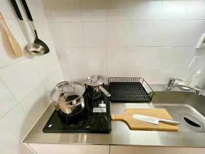 a kitchen counter with a stove with pots and pans at SALON Shibuya in Tokyo