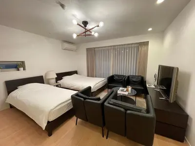 a bedroom with a bed and a couch and a tv at SALON Shibuya in Tokyo