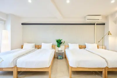 two beds in a room with white sheets at STAY ARI Arakicho in Tokyo