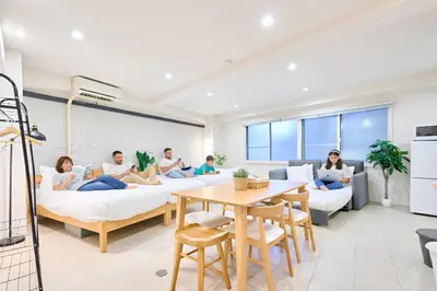 a group of people sitting on beds in a room at STAY ARI Arakicho in Tokyo