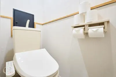 a bathroom with a toilet with a remote control at STAY ARI Arakicho in Tokyo