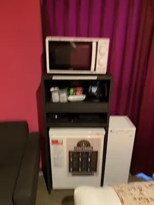 a microwave sitting on a stand with a microwave at Roppongi Plaza Hotel in Tokyo