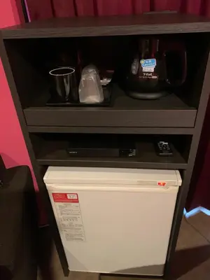 a dresser with a tv and a shelf on top at Roppongi Plaza Hotel in Tokyo