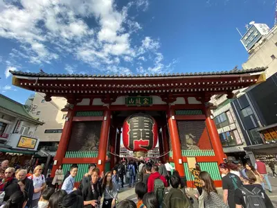 a crowd of people walking in front of a shrine at HOTEL Japonica in Tokyo