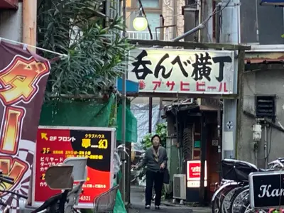 a man walking down a street in an asian city at HOTEL Japonica in Tokyo