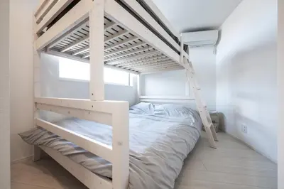 a bedroom with a bunk bed and a ladder at Private Hotel Oshiage in Tokyo