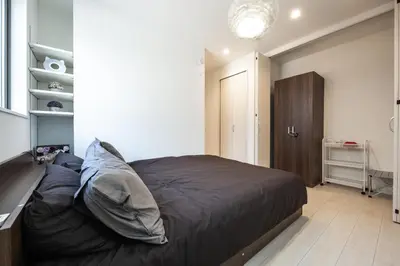 a bedroom with a large bed and a closet at Private Hotel Oshiage in Tokyo