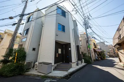 a white building with a lot of wires above it at Private Hotel Oshiage in Tokyo