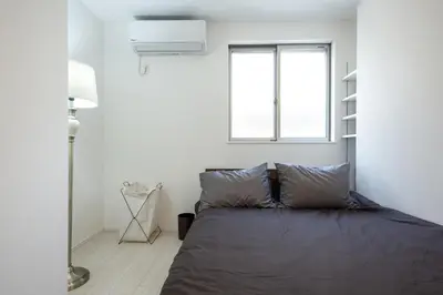 a bedroom with a bed and a window at Private Hotel Oshiage in Tokyo