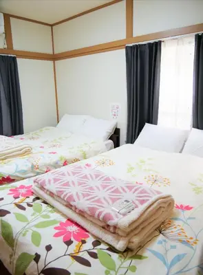 two beds sitting next to each other in a bedroom at \u9326\u306e\u9928 Nishiki\u306eYakata in Tokyo