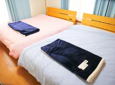 two beds with towels sitting on them in a room at \u9326\u306e\u9928 Nishiki\u306eYakata in Tokyo