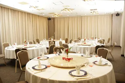 a room with tables and chairs with white tablecloths at Marroad Inn Akasaka in Tokyo