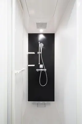a shower in a bathroom with a black wall at HOTEL TAVINOS Asakusa in Tokyo