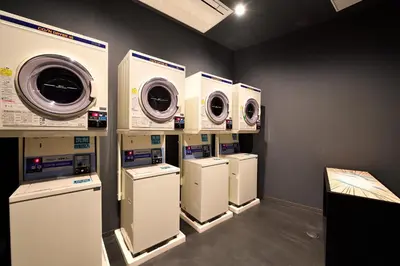 a row of washing machines and dryers in a room at HOTEL TAVINOS Asakusa in Tokyo