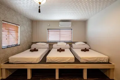 two beds in a room with two windows at ESTABLISHMENT Asakusa in Tokyo