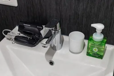 a sink with a hair dryer and a cup on it at ESTABLISHMENT Asakusa in Tokyo