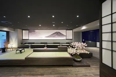 a living room with a couch and a large screen at Resol Poshtel Tokyo Asakusa in Tokyo