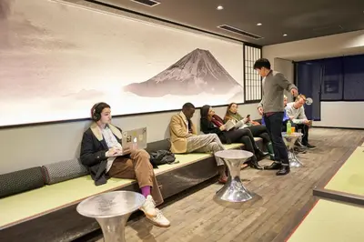 a group of people sitting on a couch in a room at Resol Poshtel Tokyo Asakusa in Tokyo