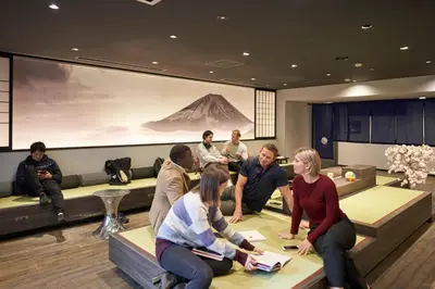 a group of people sitting in a room at Resol Poshtel Tokyo Asakusa in Tokyo