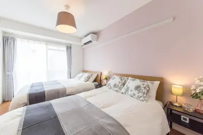 a bedroom with two beds and a window at SHINJUKU Residence BLDG in Tokyo