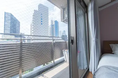 a bedroom with a balcony with a view of a city at SHINJUKU Residence BLDG in Tokyo