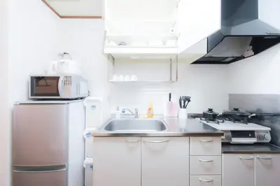 a kitchen with a sink and a refrigerator at nestay suite tokyo shibuya in Tokyo