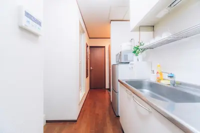 a kitchen with a sink and a refrigerator at nestay suite tokyo shibuya in Tokyo