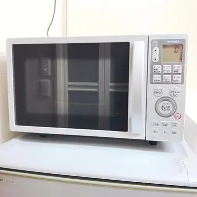 a microwave oven sitting on top of a refrigerator at nestay suite tokyo shibuya in Tokyo