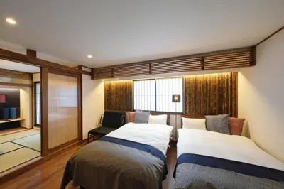 a bedroom with two beds and a television in it at YADOYA Uguisu in Tokyo