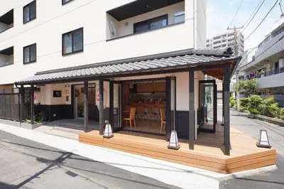 a small building with a deck on a street at YADOYA Uguisu in Tokyo