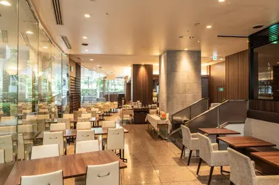 a restaurant with wooden tables and white chairs at Hotel Mystays Premier Hamamatsucho in Tokyo